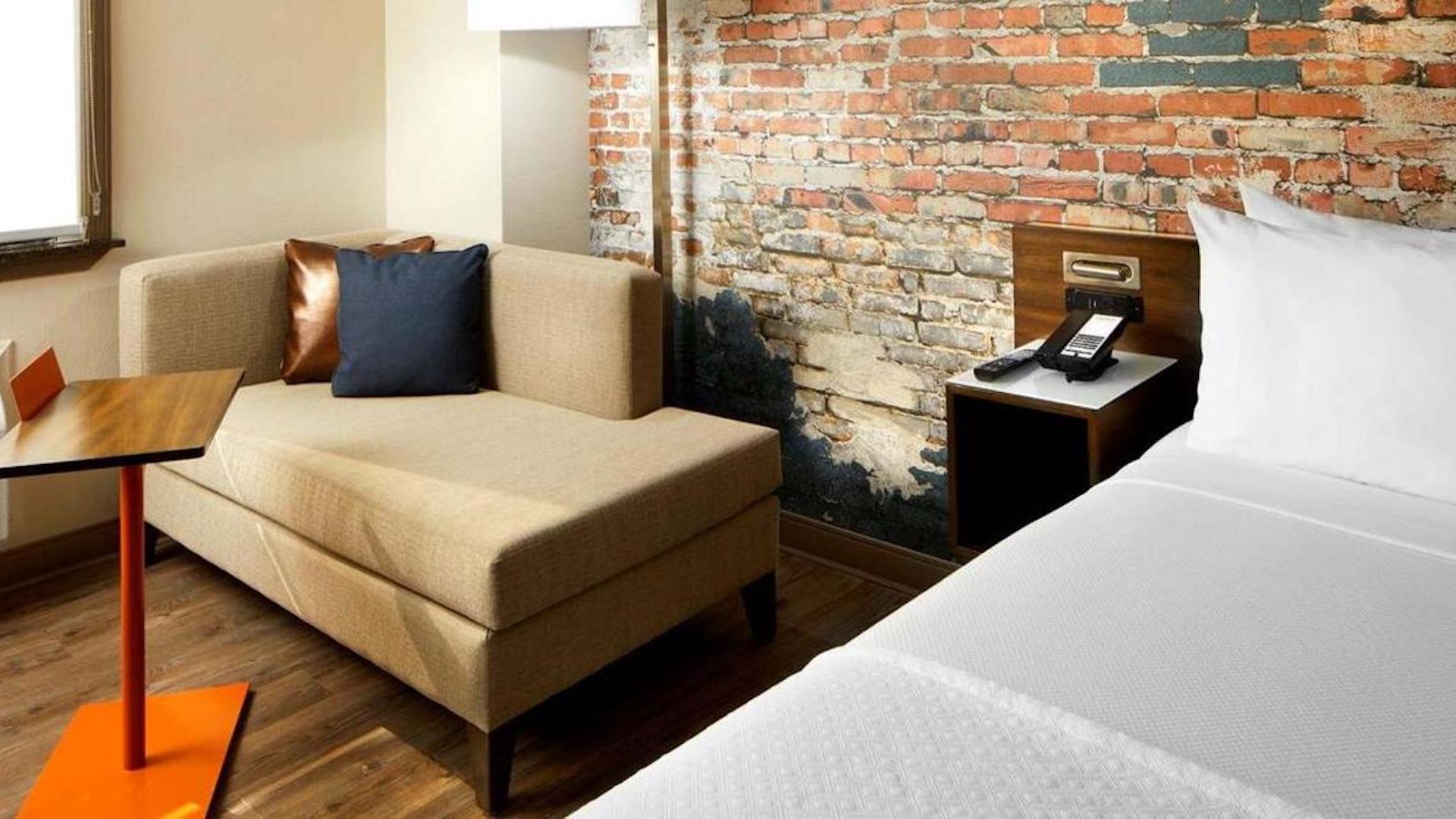 A Couch And A Table In A Room With A Brick Wall